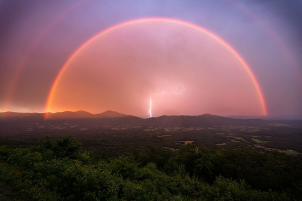 La espectacular foto de Jason Rinehart de un rayo bajo un arcoíris doble